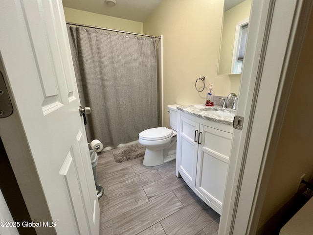 full bathroom featuring vanity, toilet, wood finished floors, and curtained shower