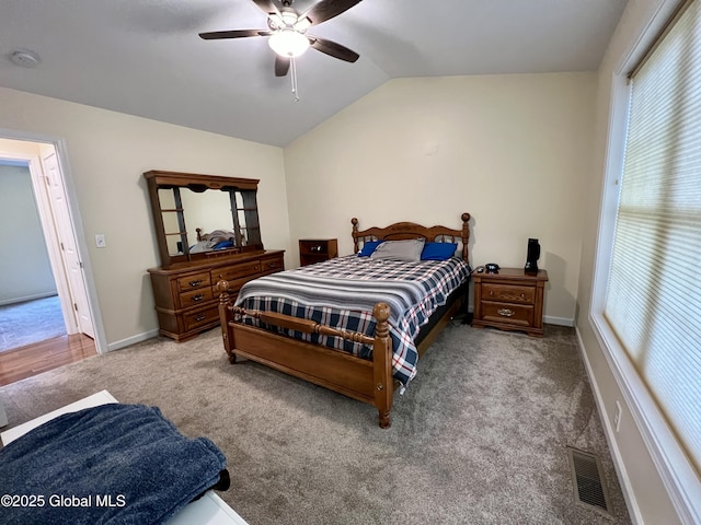 bedroom featuring vaulted ceiling, carpet, multiple windows, ceiling fan, and baseboards