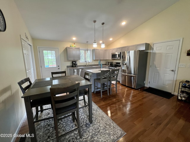 dining room with dark wood-type flooring, lofted ceiling, recessed lighting, and baseboards