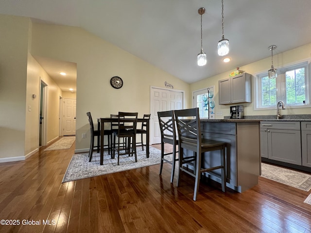 kitchen with gray cabinetry, dark wood finished floors, lofted ceiling, and healthy amount of natural light