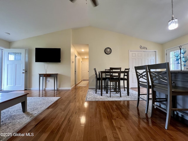 dining space featuring lofted ceiling, dark wood-style floors, and baseboards