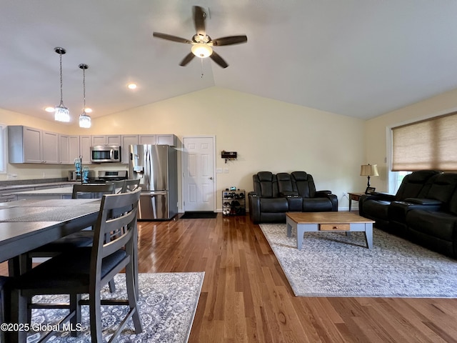 living room featuring lofted ceiling, ceiling fan, and wood finished floors