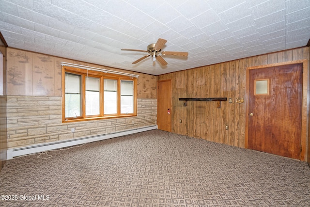 17-19 Smith Ct, North Greenbush, NY 12198 - carpeted empty room featuring a baseboard radiator, wood walls, and ceiling fan