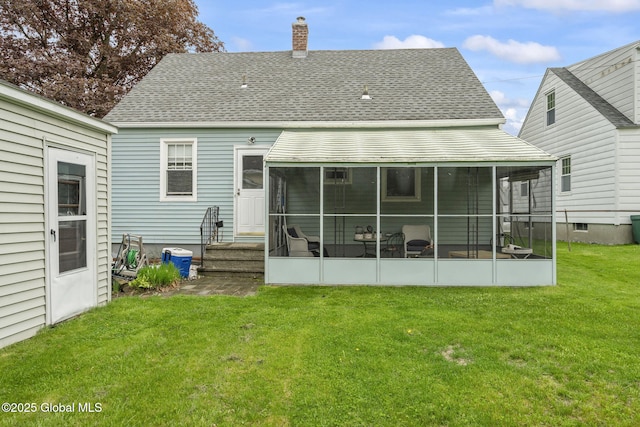 rear view of house featuring a sunroom, a chimney, a lawn, and a shingled roof