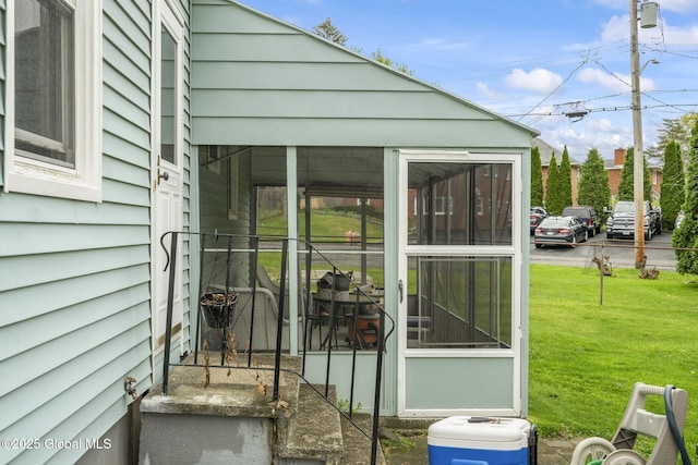 exterior space featuring a sunroom and a lawn