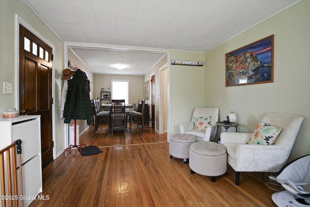 sitting room with hardwood / wood-style floors and ornamental molding