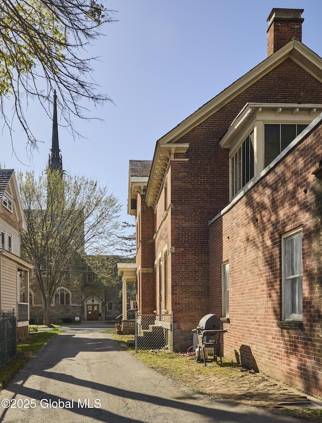 view of side of home with a chimney and brick siding
