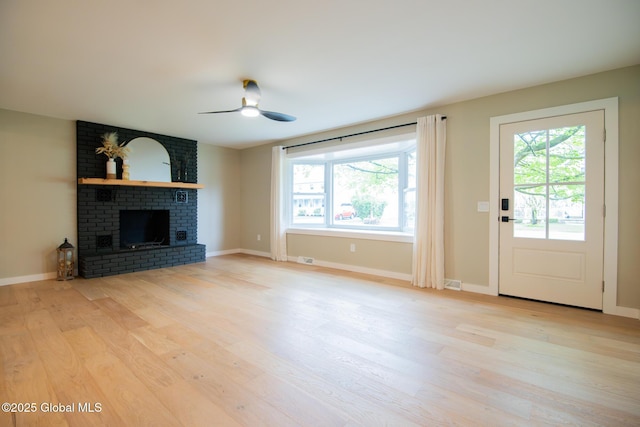 unfurnished living room featuring ceiling fan, light wood-style flooring, and healthy amount of natural light