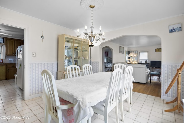 1834 Western Ave, Guilderland, NY 12203 - dining area featuring a chandelier, arched walkways, a wainscoted wall, ornamental molding, and baseboards