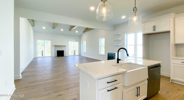 kitchen with a fireplace, a sink, dishwasher, light wood-style floors, and recessed lighting