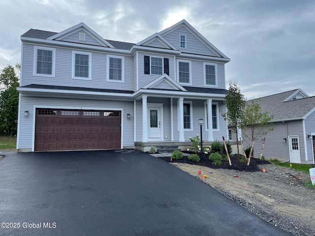 view of front of property with covered porch, an attached garage, and driveway