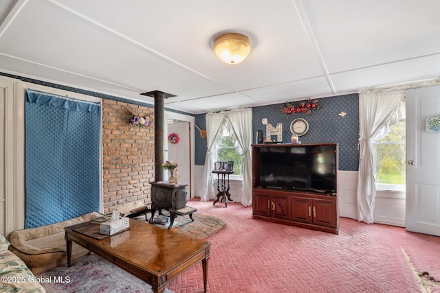 12098 Duanesburg Rd, Duanesburg, NY 12053 - living room featuring wallpapered walls, light colored carpet, a wood stove, and a wainscoted wall