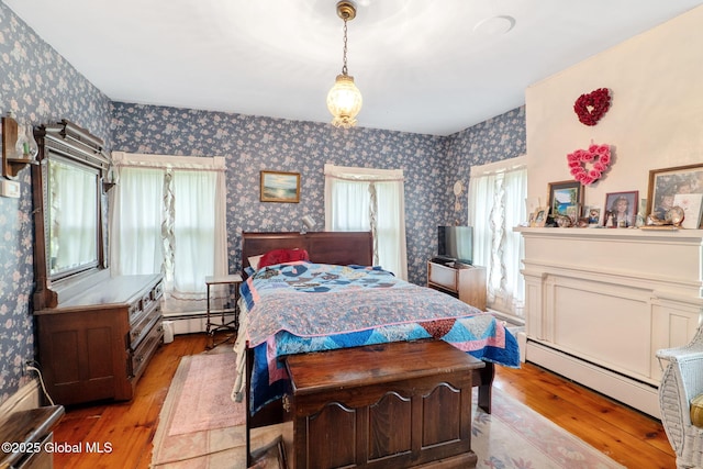12098 Duanesburg Rd, Duanesburg, NY 12053 - bedroom featuring wallpapered walls, multiple windows, a baseboard radiator, and hardwood / wood-style flooring