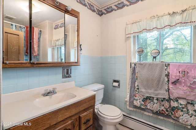 12098 Duanesburg Rd, Duanesburg, NY 12053 - full bathroom with a baseboard heating unit, tile walls, toilet, vanity, and wainscoting