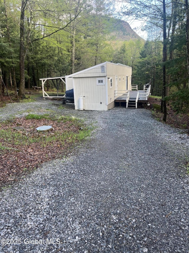 434 Old Stage Rd, Lake Luzerne, NY 12846 - view of side of property featuring gravel driveway, a view of trees, and a deck with mountain view