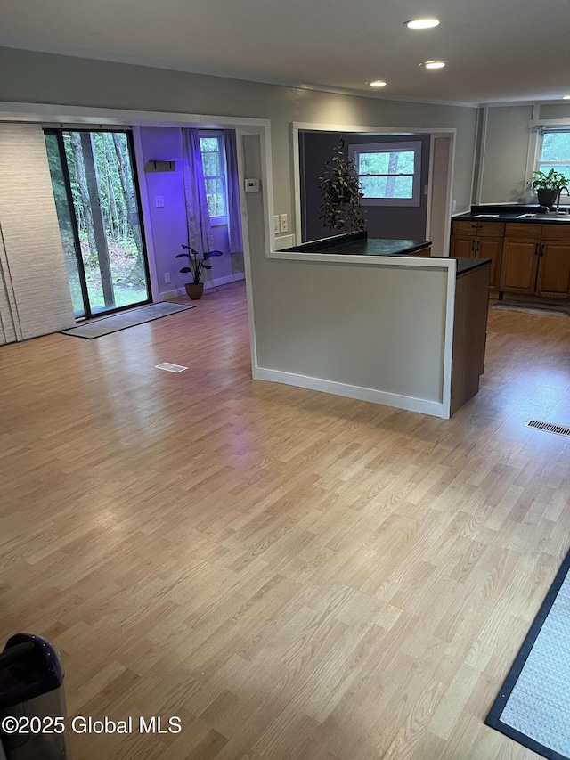 434 Old Stage Rd, Lake Luzerne, NY 12846 - kitchen with light wood-type flooring, dark countertops, recessed lighting, baseboards, and brown cabinets
