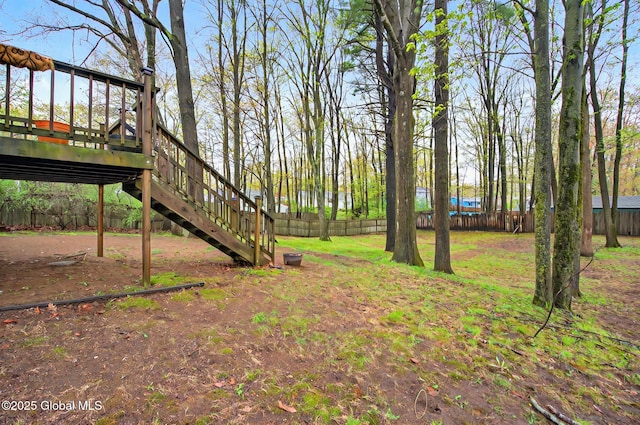 fenced backyard featuring stairs and a deck
