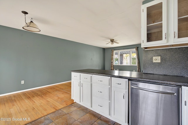kitchen featuring stainless steel dishwasher, a ceiling fan, dark countertops, white cabinets, and a peninsula