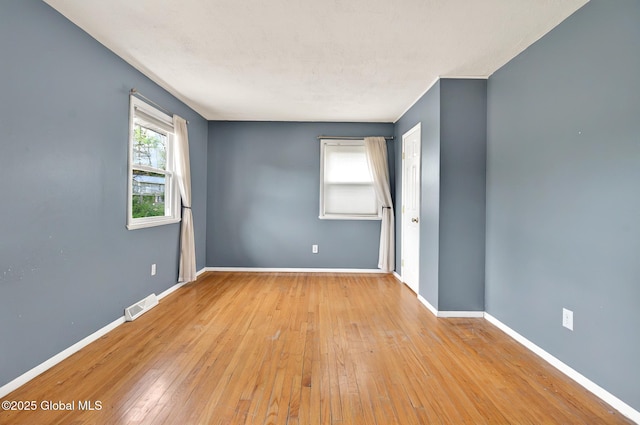 empty room with baseboards and hardwood / wood-style flooring