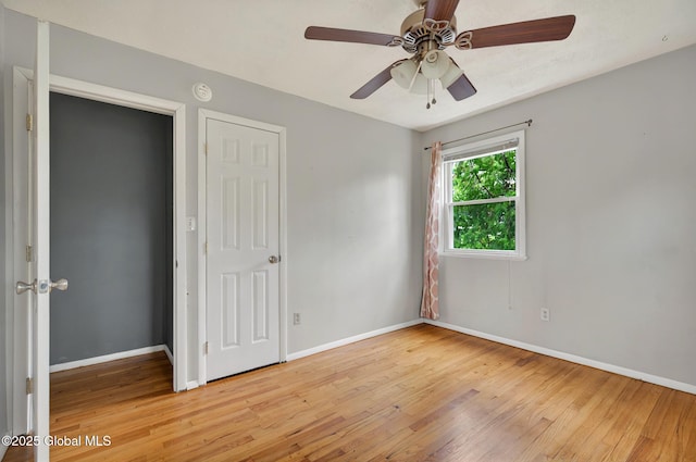 unfurnished bedroom with light wood-type flooring, baseboards, and a ceiling fan