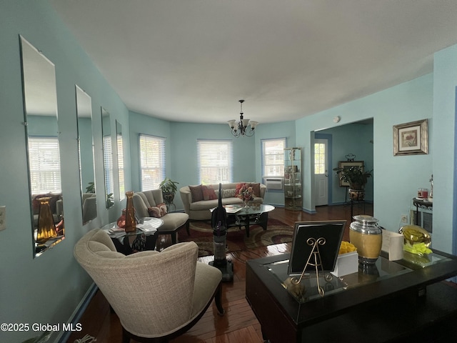 living area featuring a chandelier, dark wood finished floors, and plenty of natural light