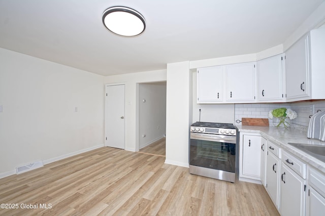30 Andrewsville Ct, Watervliet, NY 12189 - kitchen with stainless steel gas range, light wood finished floors, light countertops, and white cabinetry