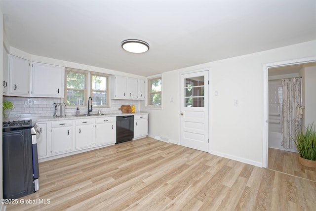 30 Andrewsville Ct, Watervliet, NY 12189 - kitchen with black dishwasher, a sink, stainless steel gas stove, light wood finished floors, and decorative backsplash