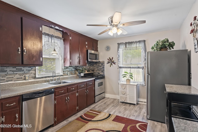 2125 Ferguson St, Rotterdam, NY 12303 - kitchen featuring appliances with stainless steel finishes, a sink, backsplash, ceiling fan, and light wood finished floors