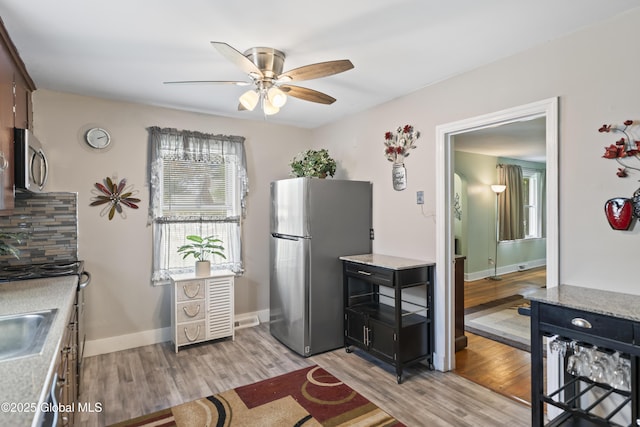 2125 Ferguson St, Rotterdam, NY 12303 - kitchen with stainless steel appliances, a ceiling fan, light wood-type flooring, light countertops, and baseboards