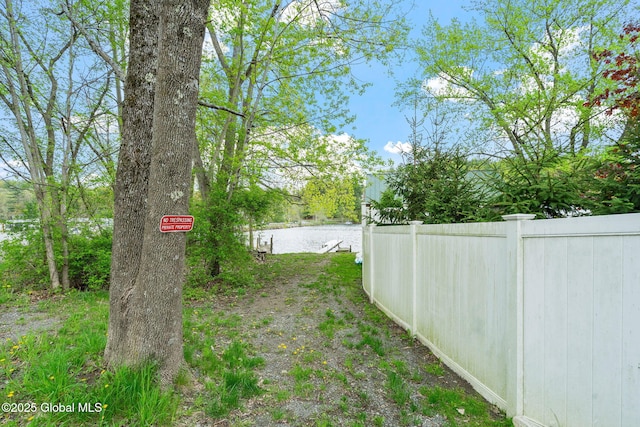 view of yard with fence and a water view