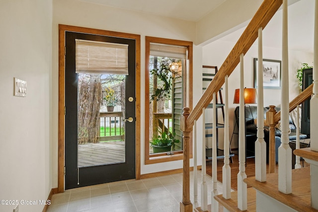 entrance foyer featuring stairs, healthy amount of natural light, and baseboards