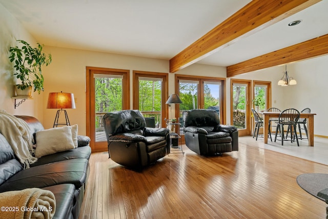living room featuring light wood-style flooring, a chandelier, beam ceiling, and recessed lighting