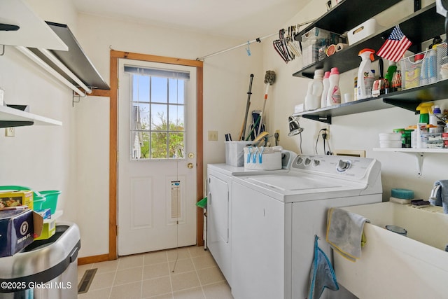 laundry room with separate washer and dryer, light tile patterned floors, and baseboards