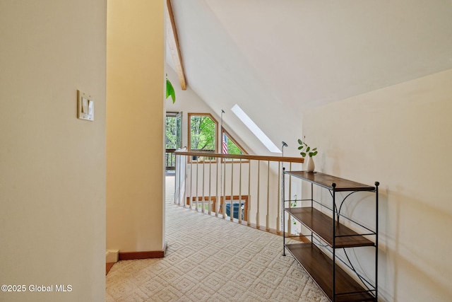 hall with a skylight and baseboards