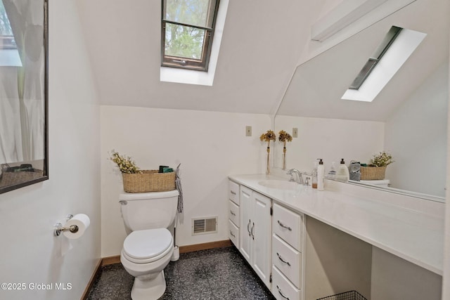 bathroom with a skylight, toilet, lofted ceiling, vanity, and baseboards