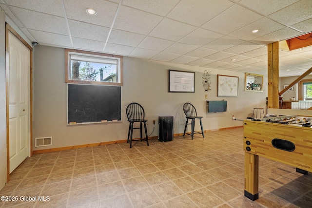 game room with a paneled ceiling, plenty of natural light, baseboards, and recessed lighting