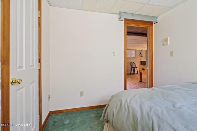 bedroom featuring carpet floors, a paneled ceiling, and baseboards