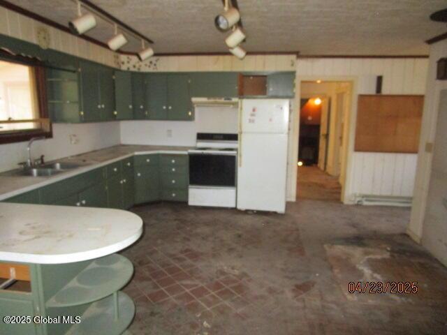 kitchen featuring freestanding refrigerator, stove, green cabinetry, and under cabinet range hood