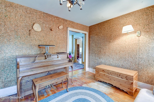 sitting room featuring wood finished floors and a chandelier