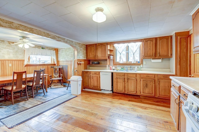 kitchen with white appliances, wainscoting, light countertops, light wood finished floors, and plenty of natural light
