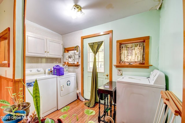 washroom with independent washer and dryer, cabinet space, and light wood-type flooring