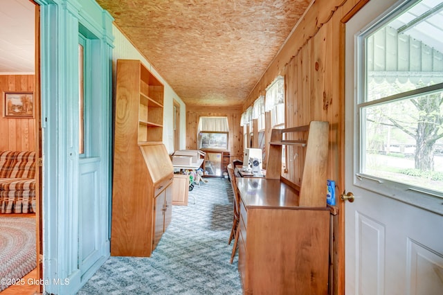 corridor with carpet flooring and wood walls