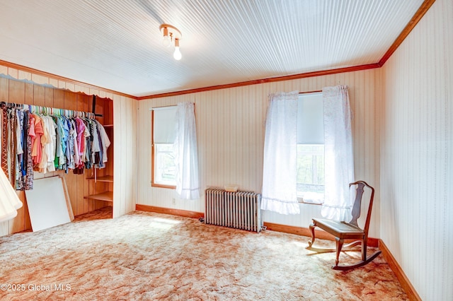 unfurnished bedroom featuring radiator, crown molding, carpet flooring, wallpapered walls, and baseboards