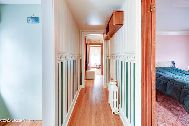 hallway with wallpapered walls and light wood finished floors