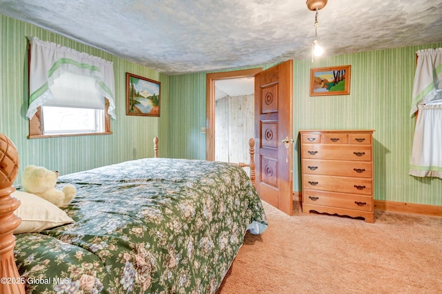carpeted bedroom featuring wallpapered walls, a textured ceiling, and baseboards