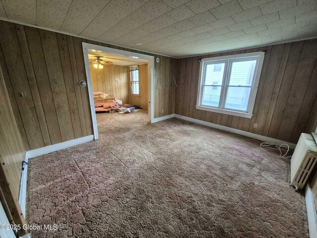 1220 5th Ave, Watervliet, NY 12189 - carpeted spare room featuring healthy amount of natural light, wood walls, and a ceiling fan