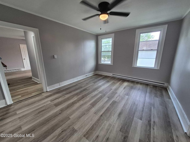 1220 5th Ave, Watervliet, NY 12189 - empty room featuring a baseboard heating unit, wood finished floors, a ceiling fan, baseboards, and crown molding