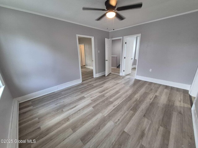 1220 5th Ave, Watervliet, NY 12189 - unfurnished bedroom featuring baseboards, wood finished floors, crown molding, and ceiling fan
