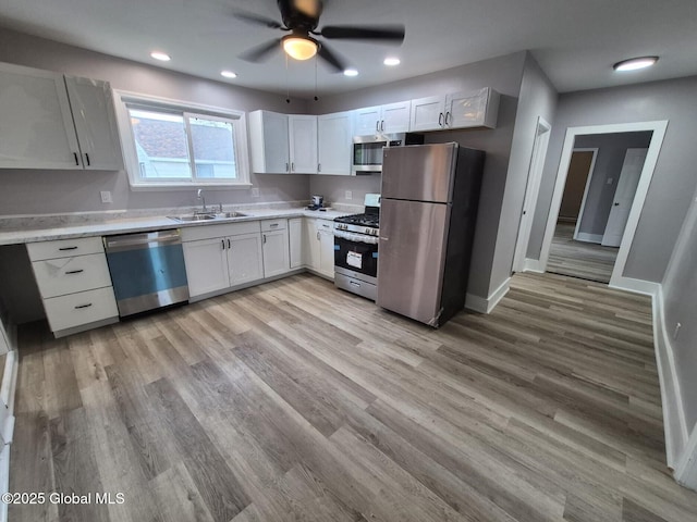 1220 5th Ave, Watervliet, NY 12189 - kitchen with appliances with stainless steel finishes, a sink, light countertops, a ceiling fan, and light wood-style floors
