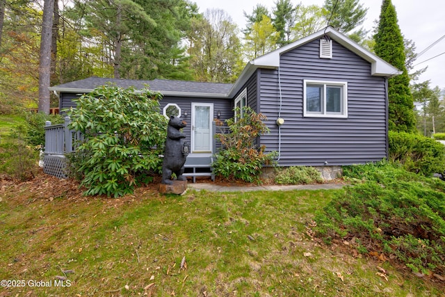 view of front of property with a front yard and roof with shingles